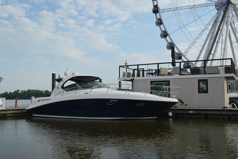 Slide: The Image of 2007 Sea Ray 38 Sundancer yacht docked near a Ferris wheel on a sunny day. - 1
