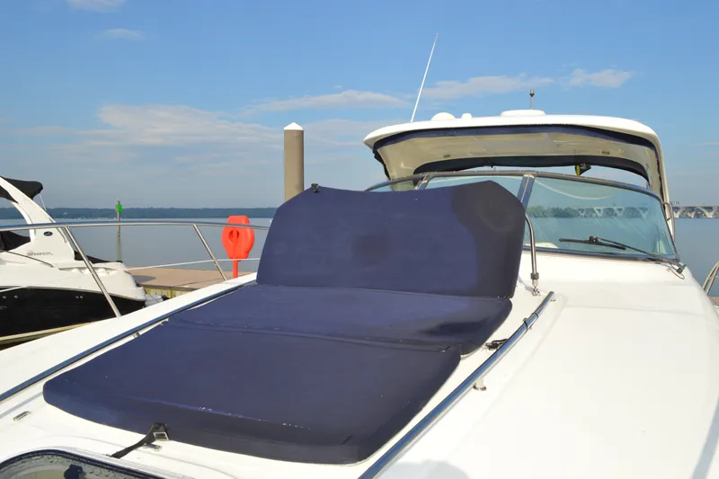 Slide: The Image of 2007 Sea Ray 38 Sundancer yacht with blue sunbed, docked by calm waters. - 18