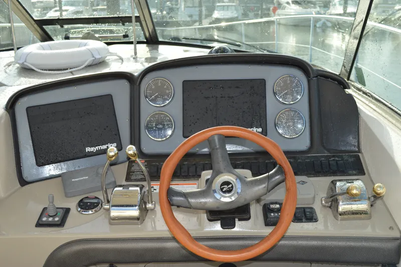 Slide: The Image of 2007 Sea Ray 38 Sundancer helm with Raymarine electronics and wooden steering wheel. - 10