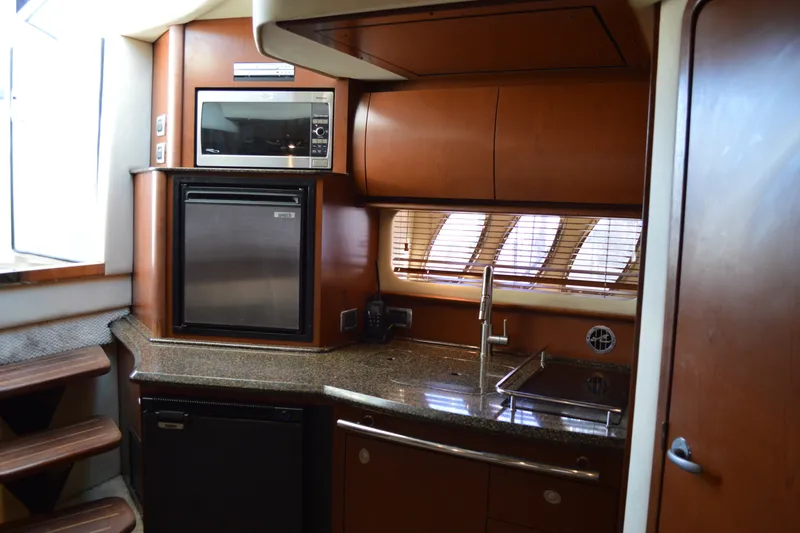 Slide: The Image of Luxurious 2007 Sea Ray 38 Sundancer yacht kitchen with modern appliances and sleek wood cabinetry. - 22