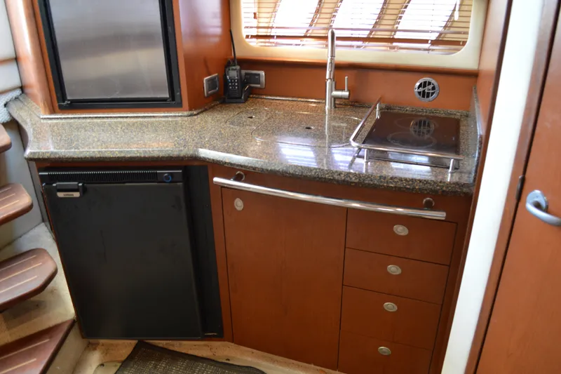 Slide: The Image of 2007 Sea Ray 38 Sundancer yacht kitchen with granite countertop, sink, and compact appliances. - 23