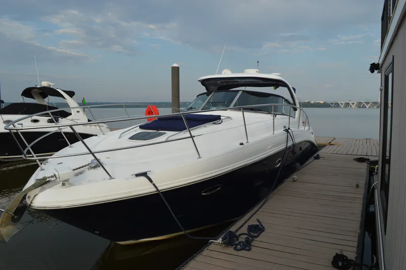 Slide: The Image of 2007 Sea Ray 38 Sundancer yacht docked at marina under cloudy sky. - 2