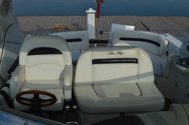 Slide: The Image of 2007 Sea Ray 38 Sundancer cockpit with white leather seating and wooden steering wheel. - 9