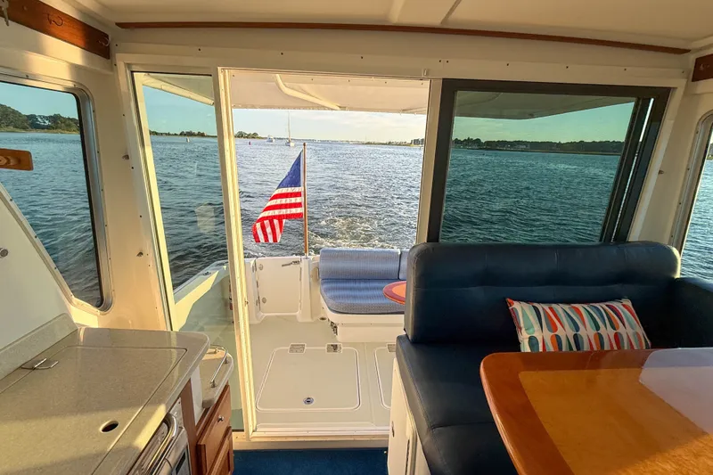 Slide: The Image of Interior view of 2016 Back Cove 34 yacht with American flag and scenic water backdrop. - 34