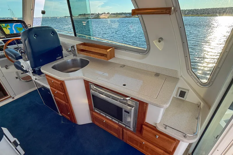 Slide: The Image of Interior of 2016 Back Cove 34 yacht with kitchenette and helm, overlooking water. - 14