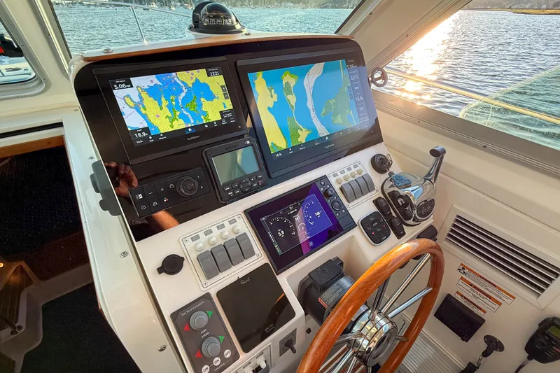 Slide: The Image of Helm of 2016 Back Cove 34 boat with navigation screens and wooden steering wheel. - 21