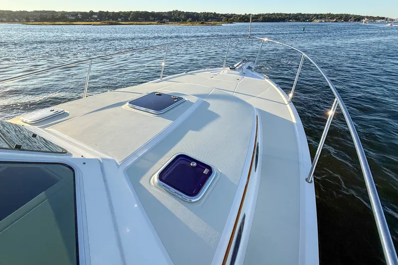Slide: The Image of 2016 Back Cove 34 boat deck with hatches, cruising on calm waters. - 35