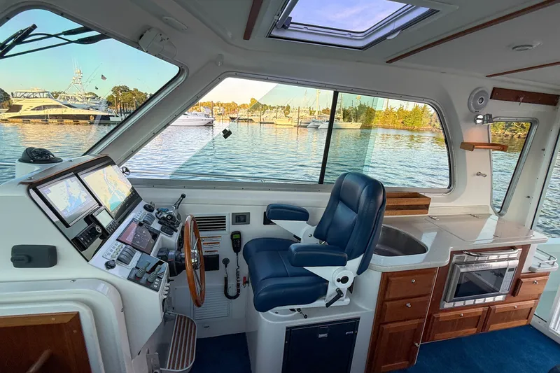Slide: The Image of Interior of a 2016 Back Cove 34 boat with helm, navigation screens, and kitchenette. - 18