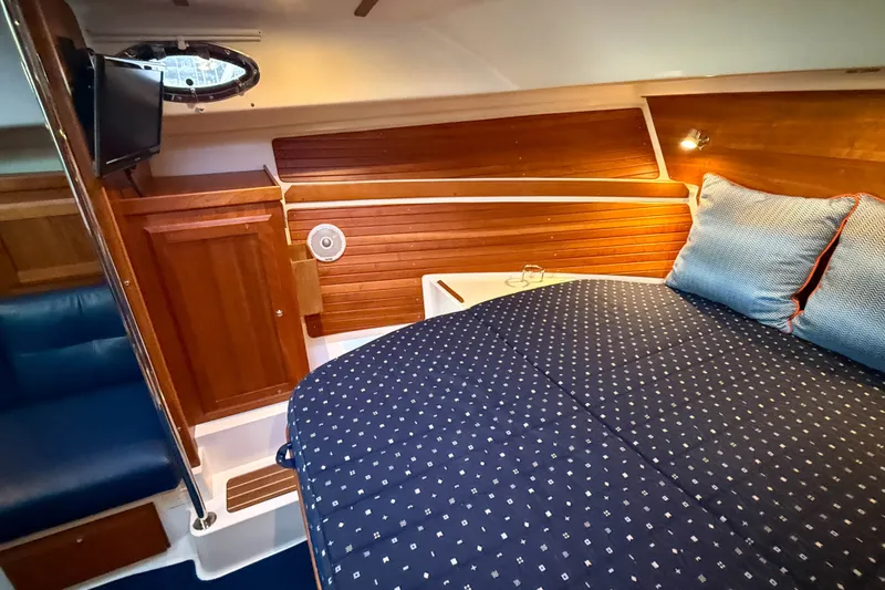 Slide: The Image of Cozy cabin interior of 2016 Back Cove 34 with wood paneling and comfortable bedding. - 29