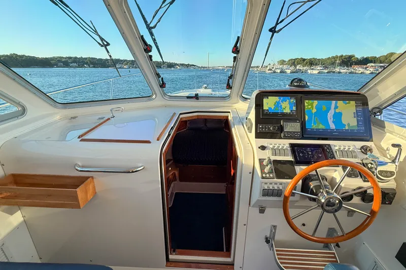 Slide: The Image of Interior view of 2016 Back Cove 34 boat cockpit with navigation equipment and scenic waterway. - 24