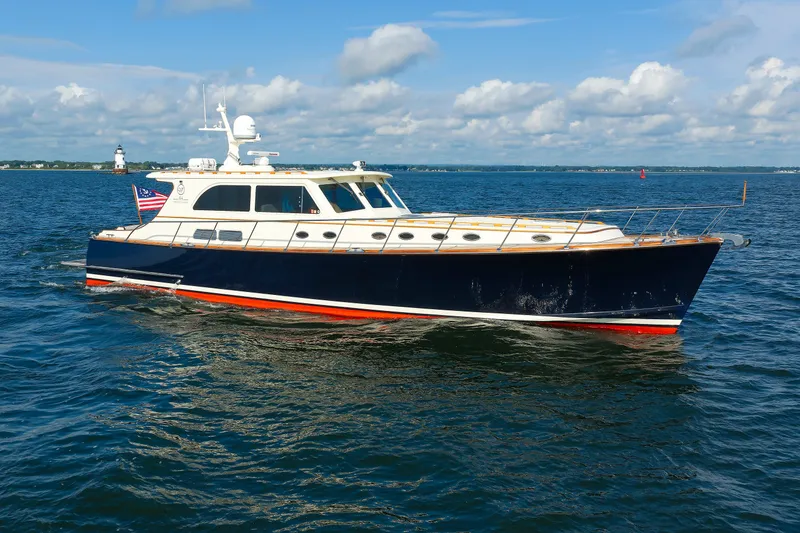 Slide: The Image of 2010 Vicem 64 yacht cruising on open water with lighthouse in background. - 16