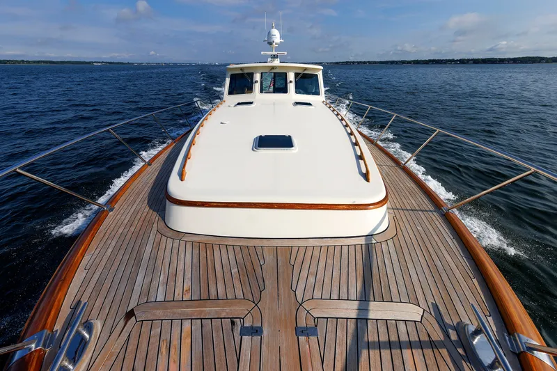 Slide: The Image of 2010 Vicem 64 yacht cruising on open water with wooden deck and sleek design. - 27
