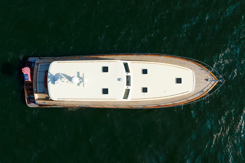 Slide: The Image of Aerial view of 2010 Vicem 64 yacht on open water, showcasing sleek design and American flag. - 14