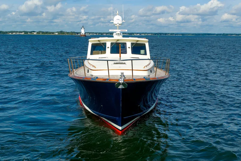 Slide: The Image of Front view of a 2010 Vicem 64 yacht on open water, with a lighthouse in the background. - 13