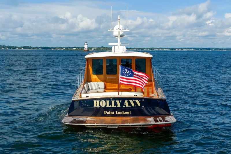 Slide: The Image of Elegant 2010 Vicem 64 yacht "Holly Ann" cruising with American flag, scenic lighthouse backdrop. - 18