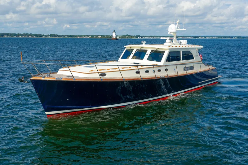 Slide: The Image of 2010 Vicem 64 yacht cruising on open water with lighthouse in background. - 21