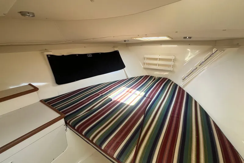 Slide: The Image of Interior cabin of 2004 Pursuit 2670 Denali LS with striped bedding. - 14