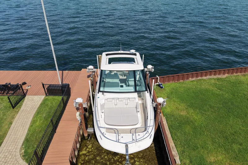Slide: The Image of 2025 Sea Ray Sundancer 320 docked by a wooden pier on a sunny day. - 6