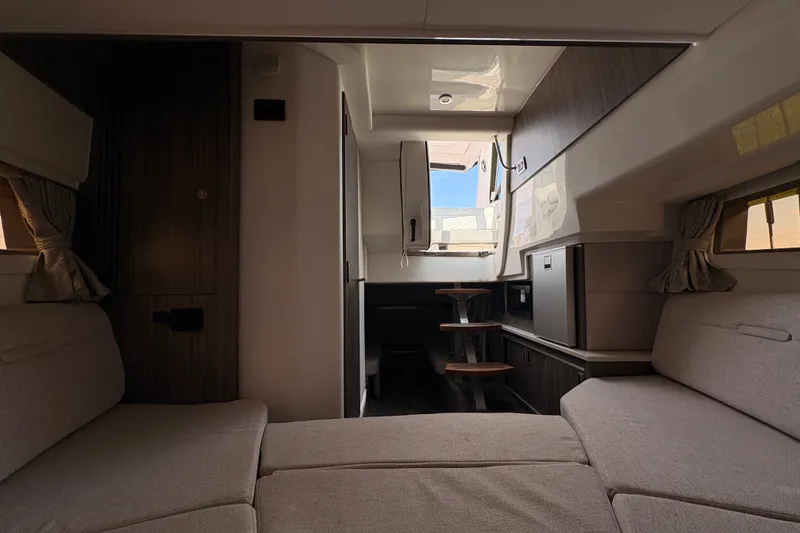 Slide: The Image of Interior of 2025 Sea Ray Sundancer 320 yacht, featuring modern seating and compact kitchenette. - 27
