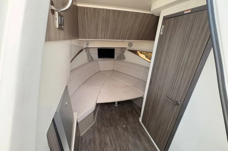 Slide: The Image of 2025 Sea Ray Sundancer 320 cabin interior with modern wood finish and cozy seating area. - 25