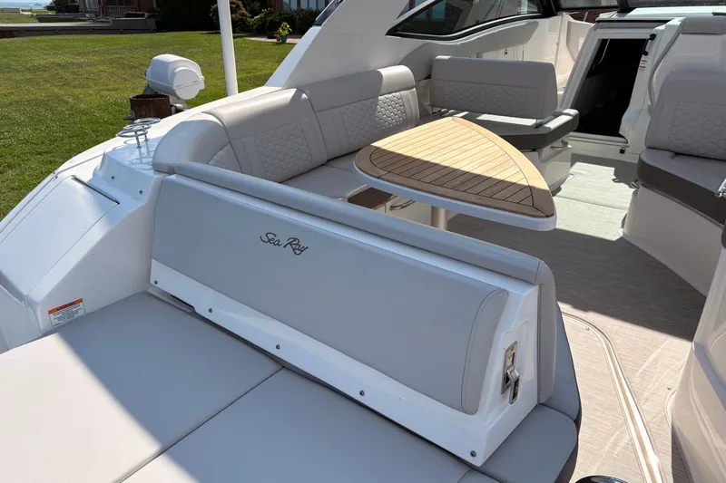 Slide: The Image of 2025 Sea Ray Sundancer 320 interior with elegant seating and wooden table. - 13