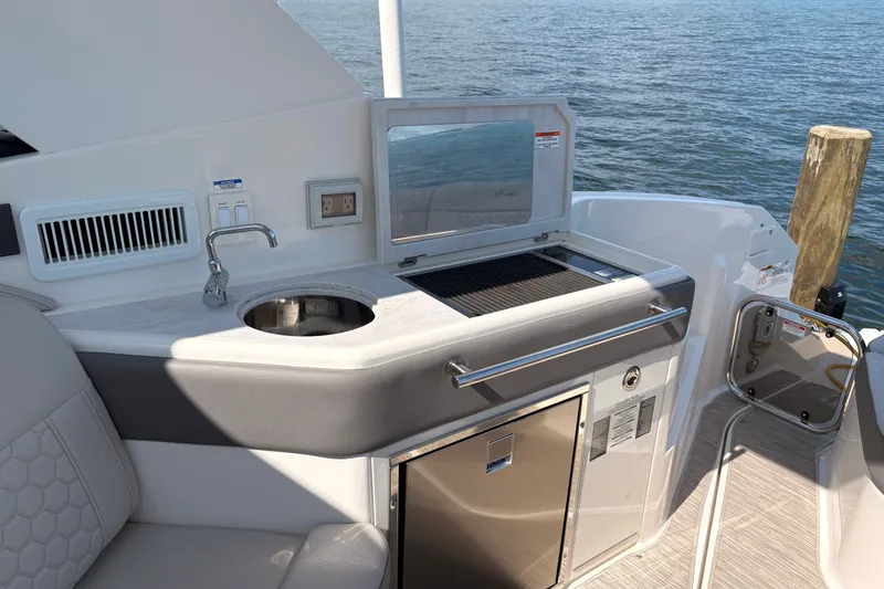 Slide: The Image of Outdoor kitchenette on 2025 Sea Ray Sundancer 320 yacht with sink and grill by the water. - 10