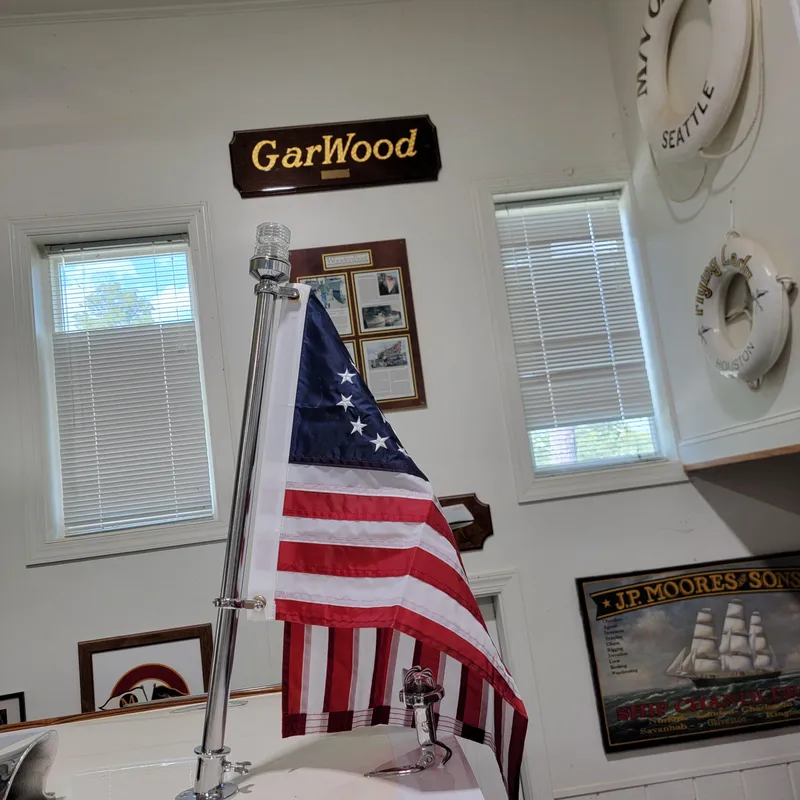 Slide: The Image of American flag indoors with nautical decor, GarWood sign, and vintage maritime memorabilia. - 26