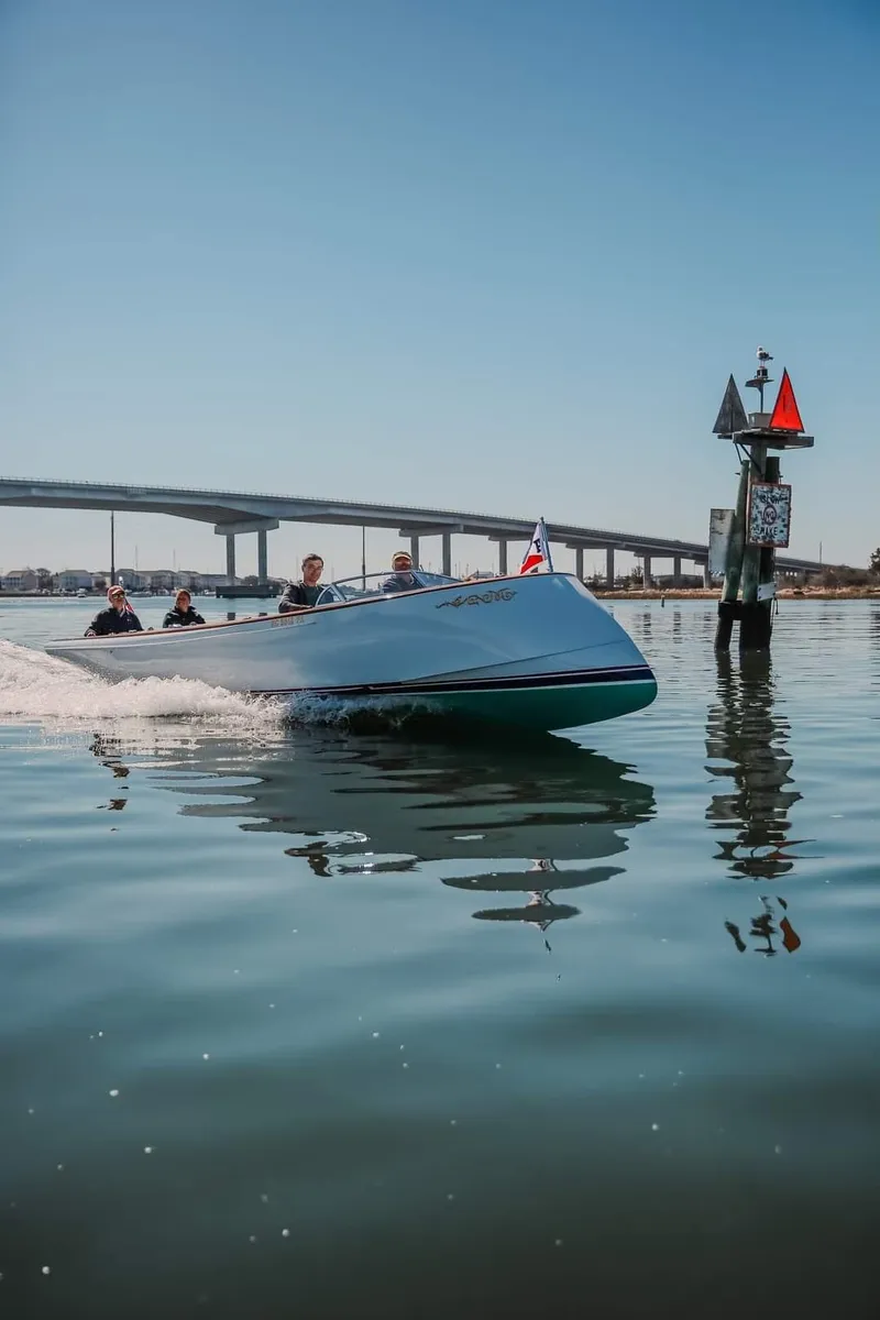Slide: The Image of Custom M27 boat cruising near a bridge and buoy, 2023 model. - 28