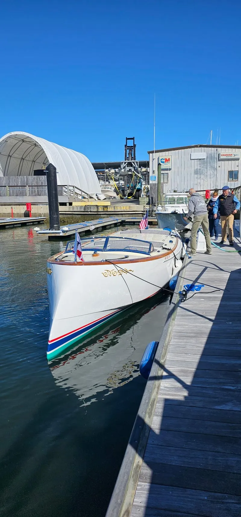 Slide: The Image of Custom M27 boat docked at marina, 2023 model, with people nearby under clear blue sky. - 27