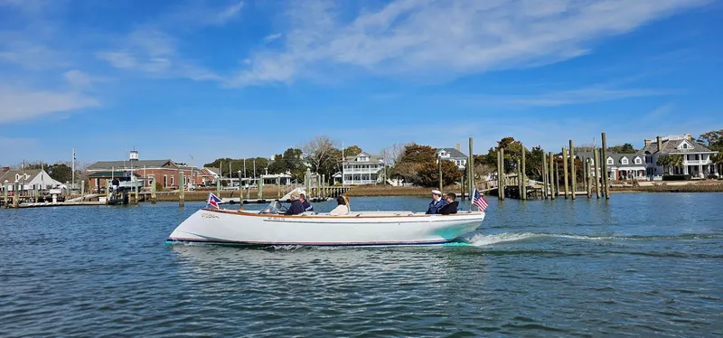 Slide: The Image of Custom M27 boat cruising on a sunny day near waterfront homes, 2023. - 29