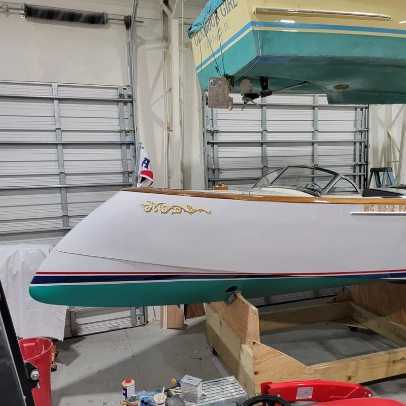 Slide: The Image of Custom M27 boat in garage, 2023 model, white and teal design, wooden accents. - 10
