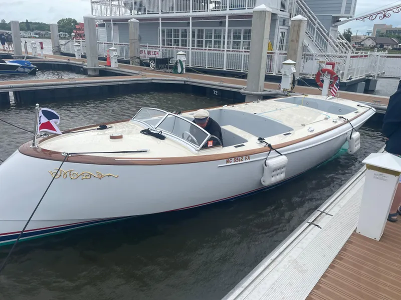 Slide: The Image of Custom M27 boat docked at marina, 2023 model, with wooden trim and nautical flags. - 32