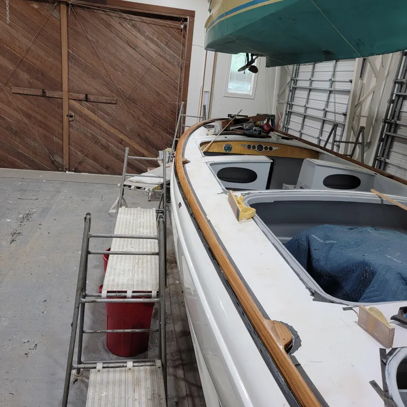 Slide: The Image of Custom M27 boat in a workshop, 2023 model, with wooden trim and tools nearby. - 17