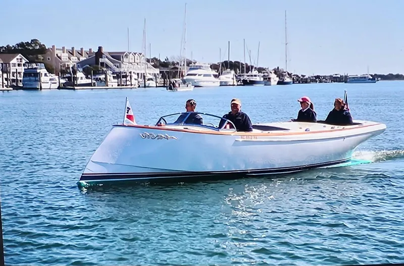 Slide: The Image of Custom M27 boat cruising in a marina, 2023 model, with passengers enjoying the ride. - 3