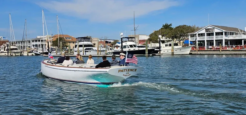 Slide: The Image of A custom 2023 M27 boat named "Patience" cruising in a marina with passengers. - 4