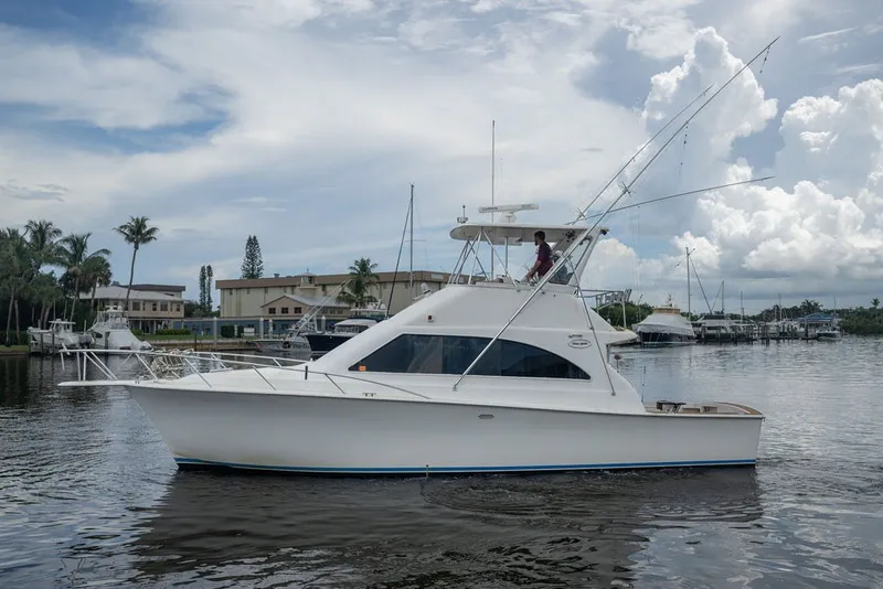 Slide: The Image of 1997 Ocean Yachts 40 Super Sport boat on calm water, with marina background. - 18