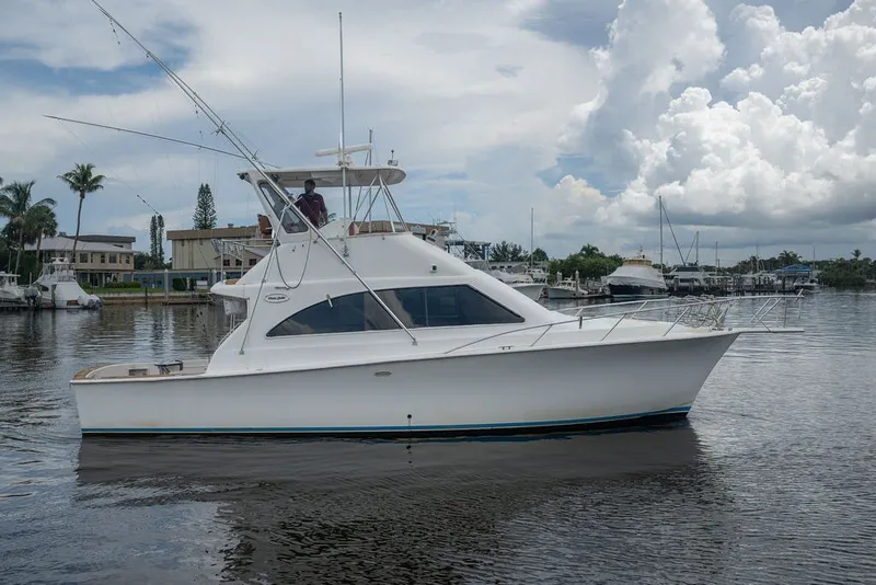 Slide: The Image of 1997 Ocean Yachts 40 Super Sport cruising on a calm marina under cloudy skies. - 10