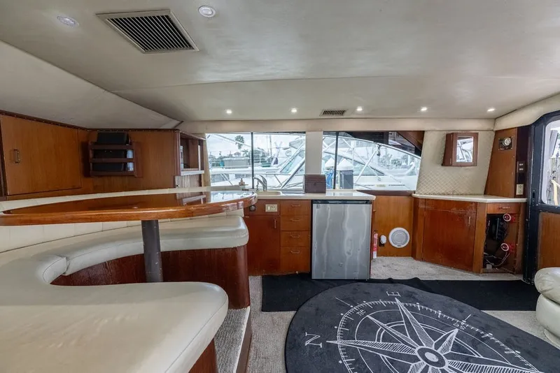 Slide: The Image of Interior of 1997 Ocean Yachts 40 Super Sport with wood cabinetry and compass-themed rug. - 54