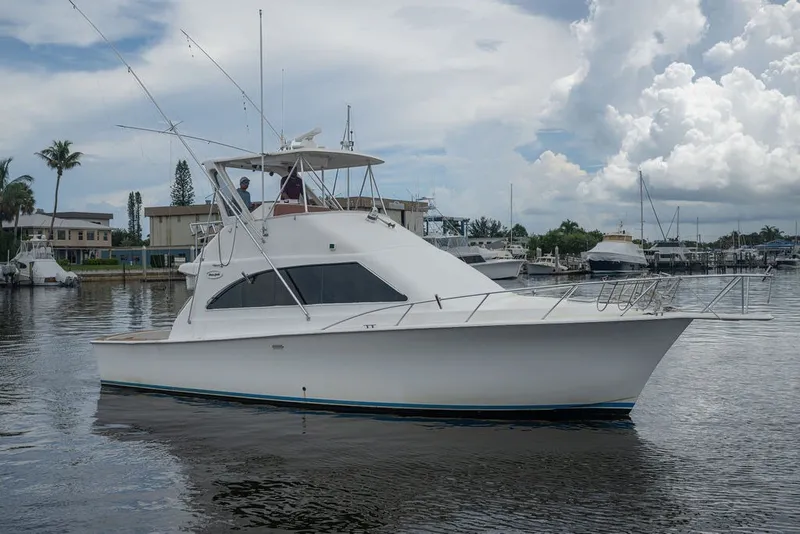 Slide: The Image of 1997 Ocean Yachts 40 Super Sport boat docked in a marina under cloudy skies. - 12