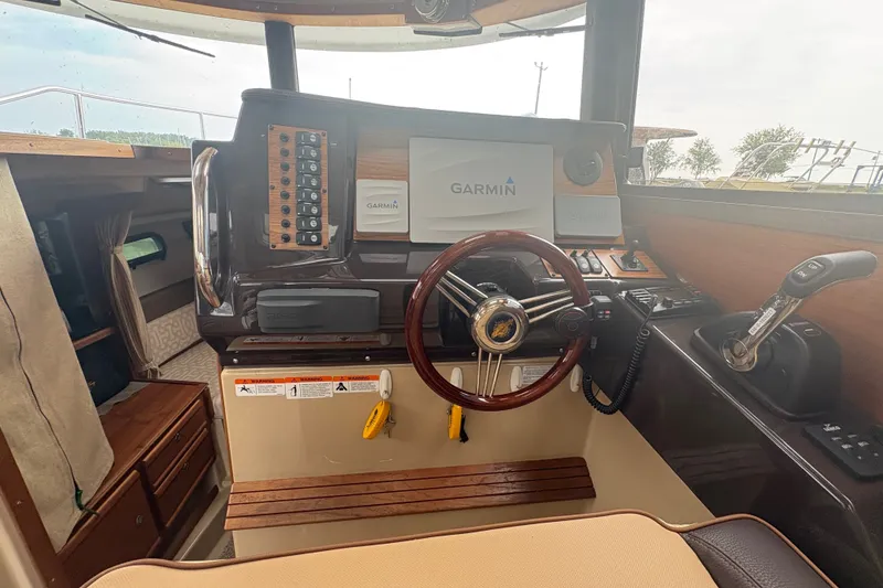 Slide: The Image of 2018 Ranger Tugs R-27 helm with Garmin navigation system and wooden steering wheel. - 19