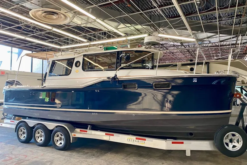 The Image of 2018 Ranger Tugs R-27 boat on trailer in indoor showroom setting. - 0