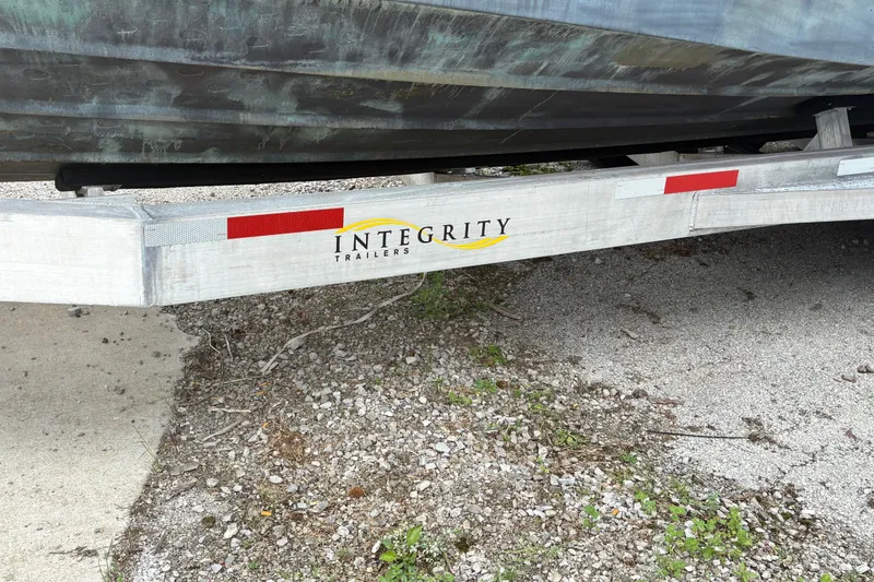 Slide: The Image of Trailer with "Integrity Trailers" logo, supporting a 2018 Ranger Tugs R-27 boat. - 10