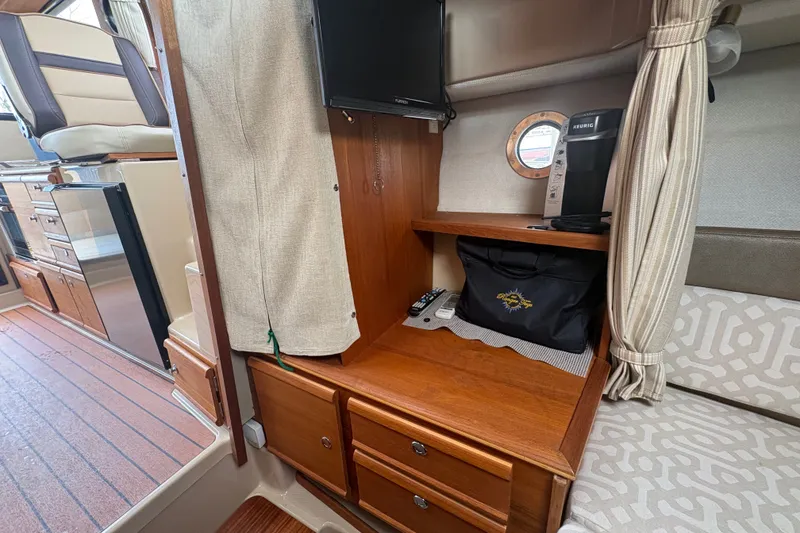 Slide: The Image of 2018 Ranger Tugs R-27 interior with wooden cabinetry, TV, and coffee maker. - 22