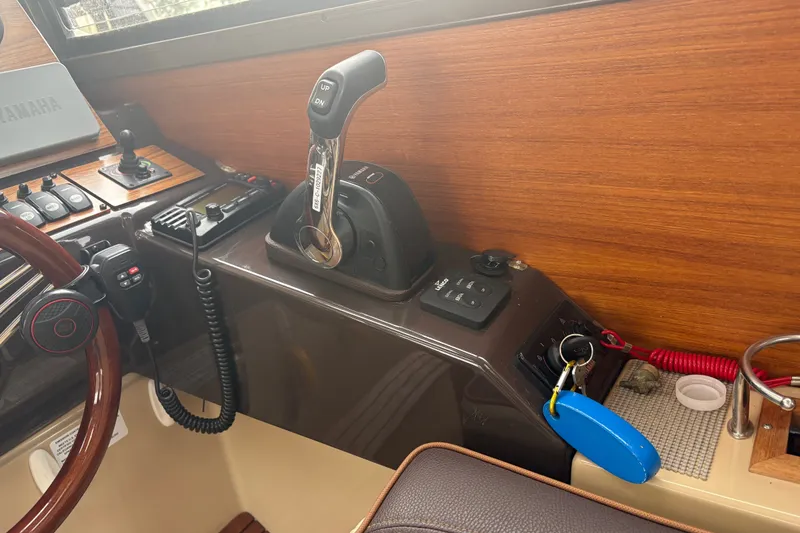 Slide: The Image of 2018 Ranger Tugs R-27 helm with controls, steering wheel, and key fob. - 21