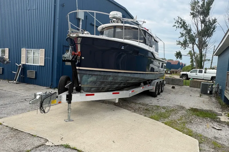 Slide: The Image of 2018 Ranger Tugs R-27 boat on trailer near blue building. - 5