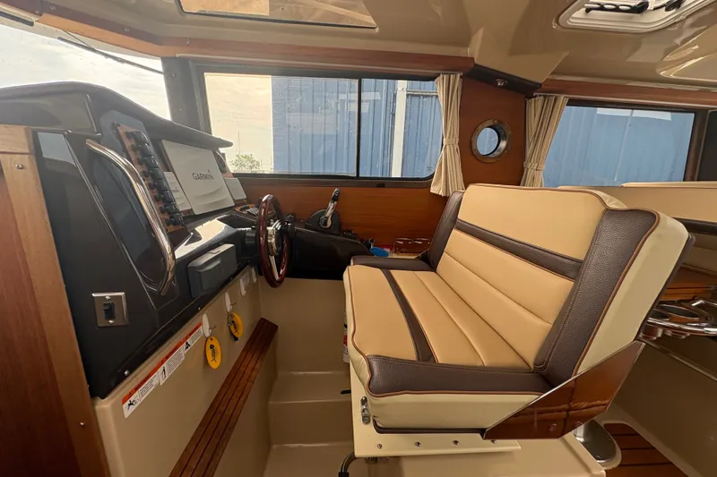 Slide: The Image of Interior of 2018 Ranger Tugs R-27 boat with helm and seating area. - 20
