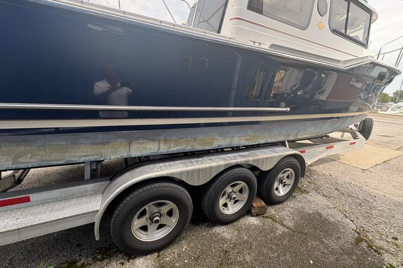 Slide: The Image of 2018 Ranger Tugs R-27 boat on a trailer, side view showing hull and wheels. - 12