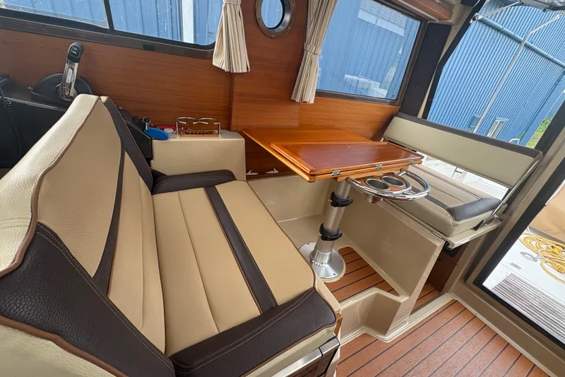 Slide: The Image of Interior of 2018 Ranger Tugs R-27 with seating and wooden table. - 15