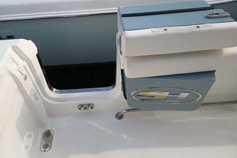 Slide: The Image of 2021 Sea Hunt Gamefish 27FS boat interior, featuring seating and storage compartment. - 26