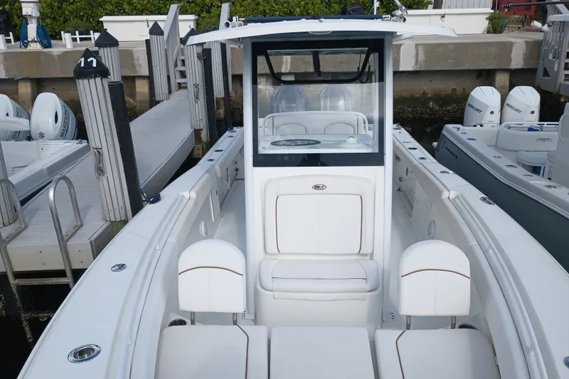 Slide: The Image of 2021 Sea Hunt Gamefish 27FS boat docked, showcasing sleek design and spacious seating. - 7